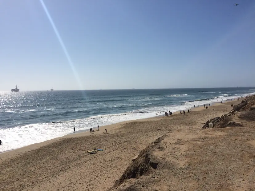 The beach below the Huntington Cliffs, with the eroded bluff edge on one side and surf along the shore