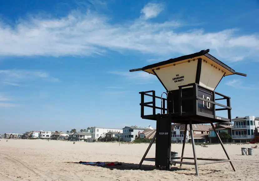 Lifeguard tower 10 on the sand at Sunset Beach, with beachfront homes behind it