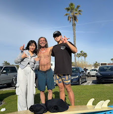 Two people standing beside surfboards