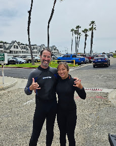 Two Surfiscool team members in wetsuits